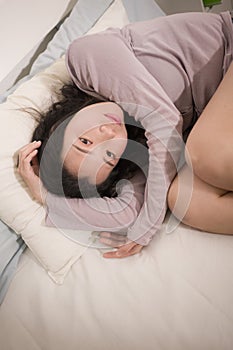 Young Asian woman depressed - young beautiful and sad  Korean girl on bed with pillow feeling unhappy and broken heart suffering