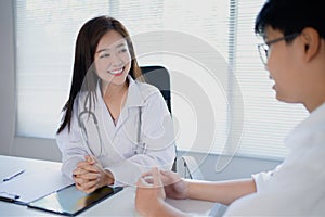 Young Asian woman doctor talking to a patient in the office