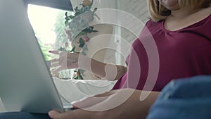 Young asian woman doing research work for her business. Smiling woman sitting on sofa relaxing while browsing online shopping.