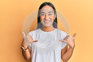 Young asian woman doing shaka sign with hands smiling with a happy and cool smile on face