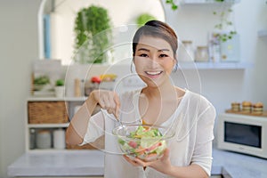 Young Asian woman eating salad vegetable in diet concept