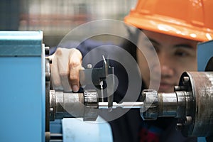 Young asian woman engineer using vernier for measure the test piece