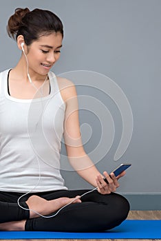 Young asian woman enjoy the music before practicing yoga