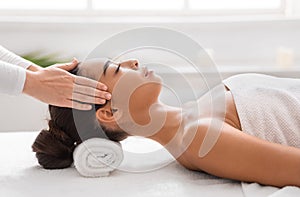 Young Asian Woman Enjoying Relaxing Head Massage During Beauty Treatment In Spa