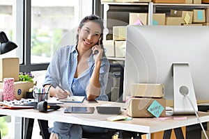 Young Asian woman entrepreneur/ Business owner working with computer at home photo