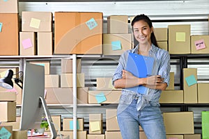 Young Asian woman entrepreneur/ Business owner working at home for online shopping and preparing package product