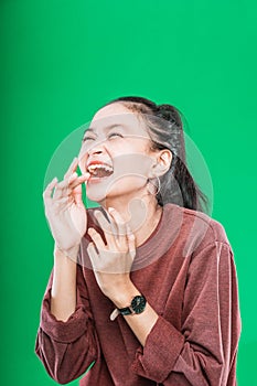 young Asian woman expressing wide-open mouth and raising hands in amazement