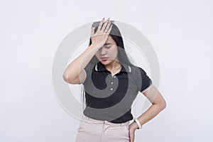 A young asian woman facepalms, realizing her mistake or forgetting something important. Frustrated reaction from blunder