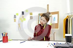 Young asian woman fashion designer stretching body for relaxing while working in home studio, small business owner, fashion