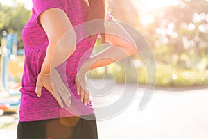 Young asian woman feel pain on her back and hip while exercising