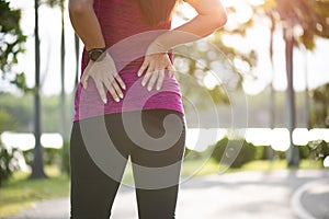 Young asian woman feel pain on her back and hip while exercising, health care concept