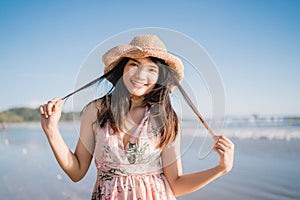 Young Asian woman feeling happy on beach, beautiful female happy relax smiling fun on beach near sea when sunset in evening.