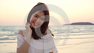 Young Asian woman feeling happy on beach, beautiful female happy relax smiling fun on beach near sea when sunset in evening.