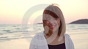 Young Asian woman feeling happy on beach, beautiful female happy relax smiling fun on beach near sea when sunset in evening.