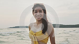 Young Asian woman feeling happy on beach, beautiful female happy relax smiling fun on beach near sea when sunset in evening.