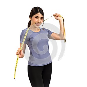 Young Asian woman in fitness clothes holding a measuring tape with a smile. Portrait on white background with studio light.