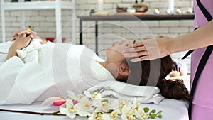 A young Asian woman getting a head massage It`s in a spa shop. Young Asian girl relaxing with hand spa massage at beauty spa salon