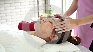 A young Asian woman getting a head massage It`s in a spa shop. Young Asian girl relaxing with hand spa massage at beauty spa salon
