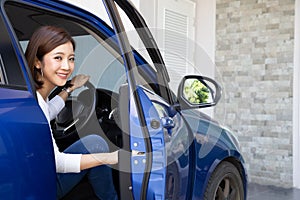 Young Asian woman getting out of a car or open door car.