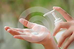 Young Asian Woman hands holding body lotion bottle and using cream for treatment skin in winter time.