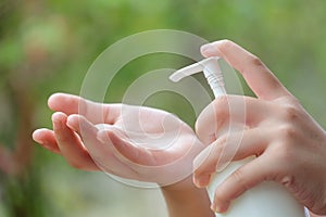 Young Asian Woman hands holding body lotion bottle and using cream for treatment skin in winter time. photo