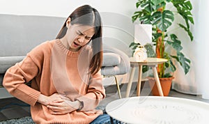 Young Asian woman hands holding the stomach and pain period cramps because having menstruation.