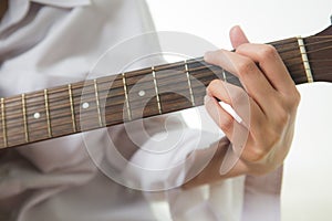 Asian woman hands touching guitar chords