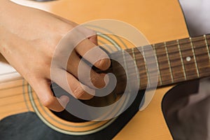 Asian woman hands touching guitar chords