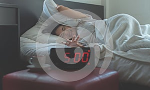 Young asian woman hates getting stressed waking up early 5 o`clock,Alarm clock