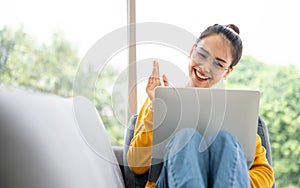 Young asian woman having conversation chatting while using laptop at house