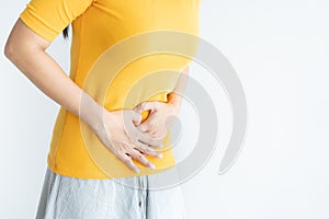 Young asian woman having painful stomachache white background.Chronic gastritis. Abdomen bloating concept photo