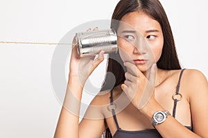 Young Asian woman hearing with tin can phone and thinking