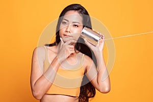 Young Asian woman hearing with tin can phone and thinking