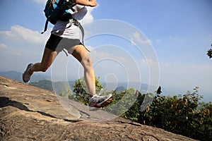 Young asian woman hiker running on mountain peak