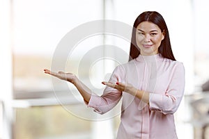 Young asian woman holding copy space on her palms.