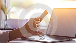 young asian woman holding credit card and computer to shopping online and paying her order People relax on holiday use technology