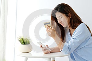 Young asian woman holding credit card and using smart phone for shopping online, business and technology concept, online payment,