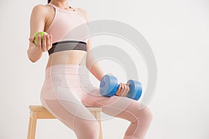 young asian woman holding a dumbbell and apple on white background,Healthy lifestyles concept of body