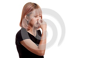 Young Asian woman holding her nose because of a bad smell.