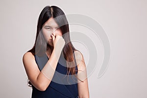 Young Asian woman holding her nose because of a bad smell.