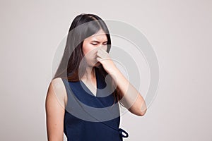 Young Asian woman holding her nose because of a bad smell.