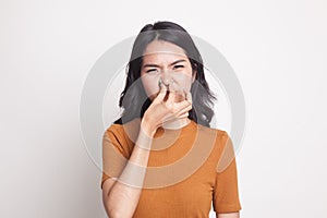 Young Asian woman holding her nose because of a bad smell.