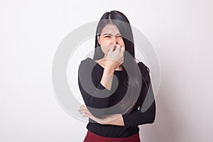 Young Asian woman holding her nose because of a bad smell.