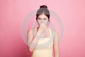 Young Asian woman holding her nose because of a bad smell.