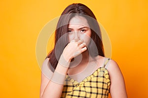 Young Asian woman holding her nose because of a bad smell.