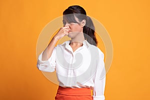 Young Asian woman  holding her nose because of a bad smell