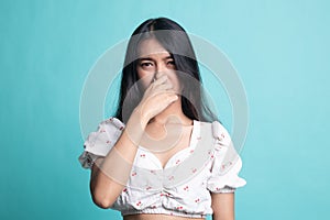 Young Asian woman  holding her nose because of a bad smell