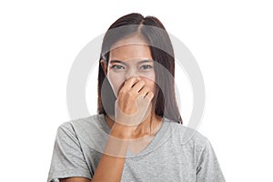 Young Asian woman holding her nose because of a bad smell.