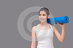 Young asian woman holding her yoga mat at healthy sport gym. Yoga and meditation have good benefits for health. Photo concept for