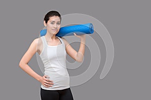 Young asian woman holding her yoga mat at healthy sport gym. Yoga and meditation have good benefits for health. Photo concept for